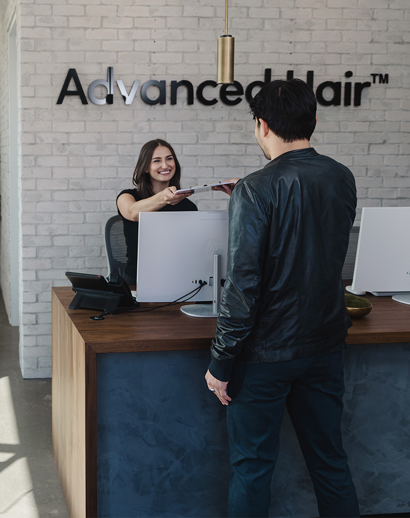 A patient arriving at the Advanced Hair reception desk